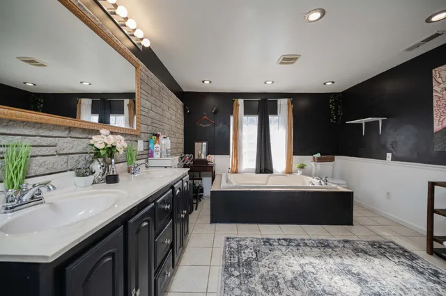 a large bathroom with double vanity and a bathtub