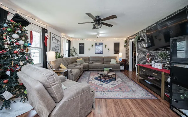 a living room with furniture a flat screen tv and a potted plant