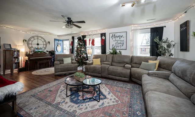a living room with furniture kitchen view and a window