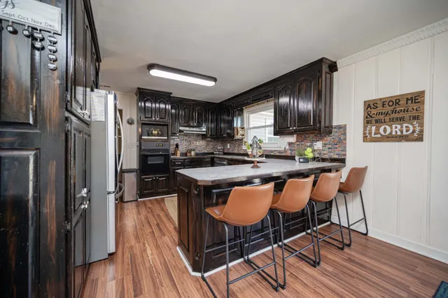 a kitchen with stainless steel appliances granite countertop a refrigerator and a stove top oven