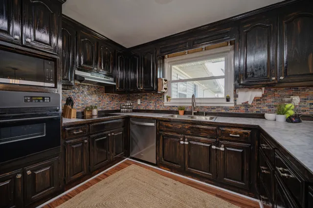 a kitchen with granite countertop stainless steel appliances and wooden cabinets