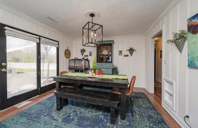 a room with wooden floor pool table and windows