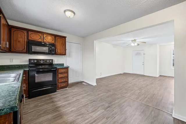 a kitchen with granite countertop a stove and a wooden floor