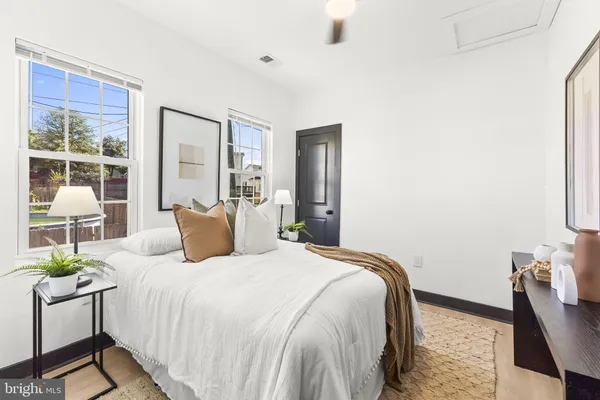 a bedroom with a bed lamp and a large window