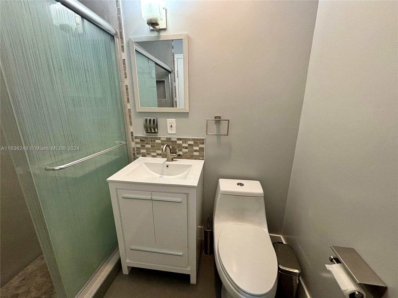 11001 Southwest 56th Street, Unit 2 Miami, FL 33165 - Photo 3 of 10 a bathroom with a toilet sink and mirror