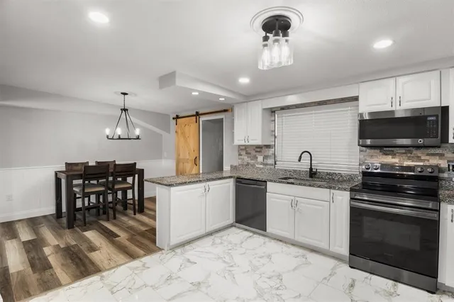 a kitchen with stainless steel appliances a stove sink microwave and cabinets