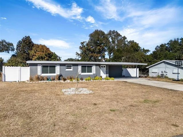 a front view of house with yard and trees in the background