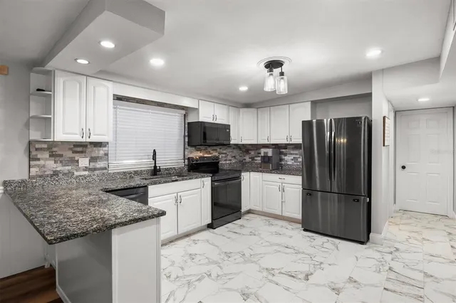 a kitchen with a refrigerator a sink and cabinets