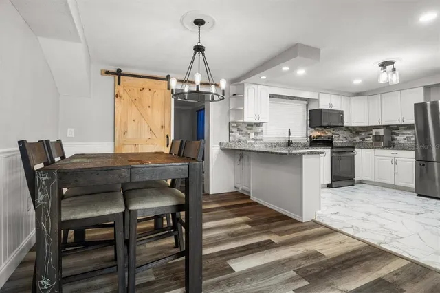 a kitchen with stainless steel appliances kitchen island a stove a table and chairs in it