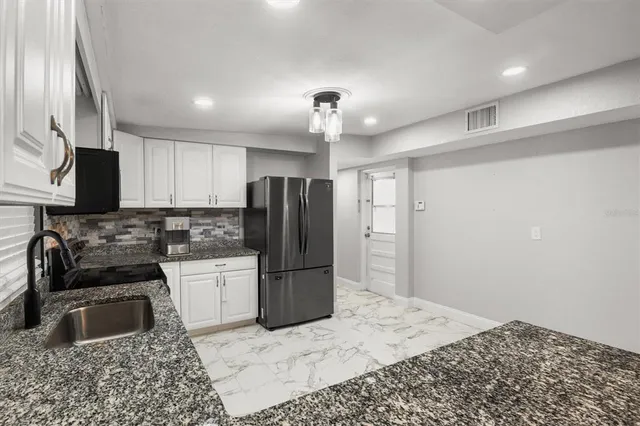 a kitchen with a refrigerator sink and wooden cabinets