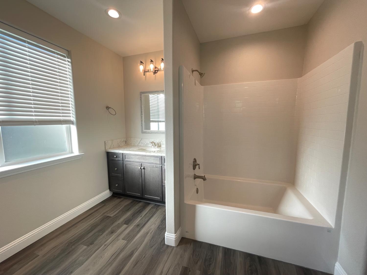 105 South Walnut Avenue Kerman, CA 93630 - Photo 11 of 22 a bathroom with a bathtub a sink and a window