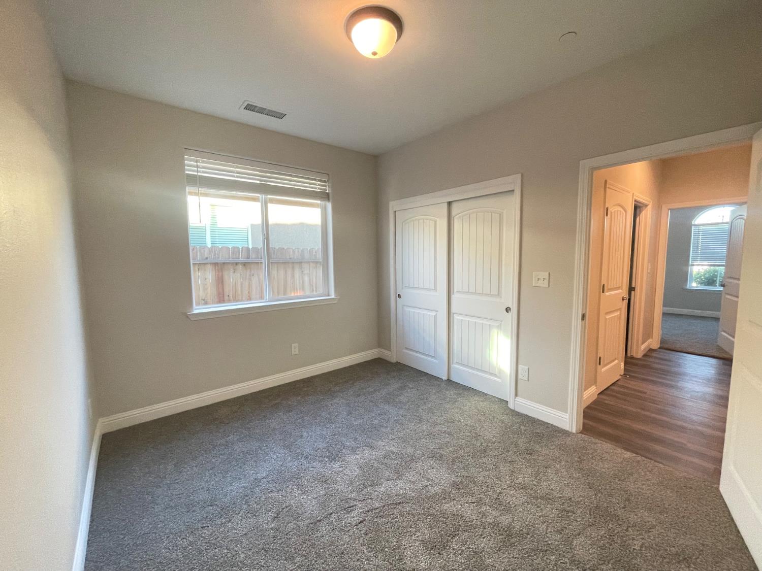 105 South Walnut Avenue Kerman, CA 93630 - Photo 14 of 22 an empty room with wooden floor and windows