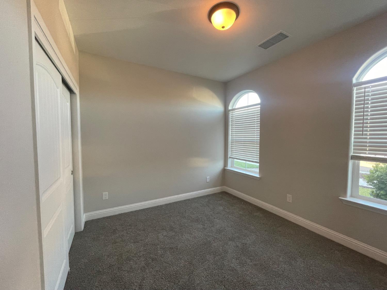 105 South Walnut Avenue Kerman, CA 93630 - Photo 16 of 22 an empty room with windows and mirror