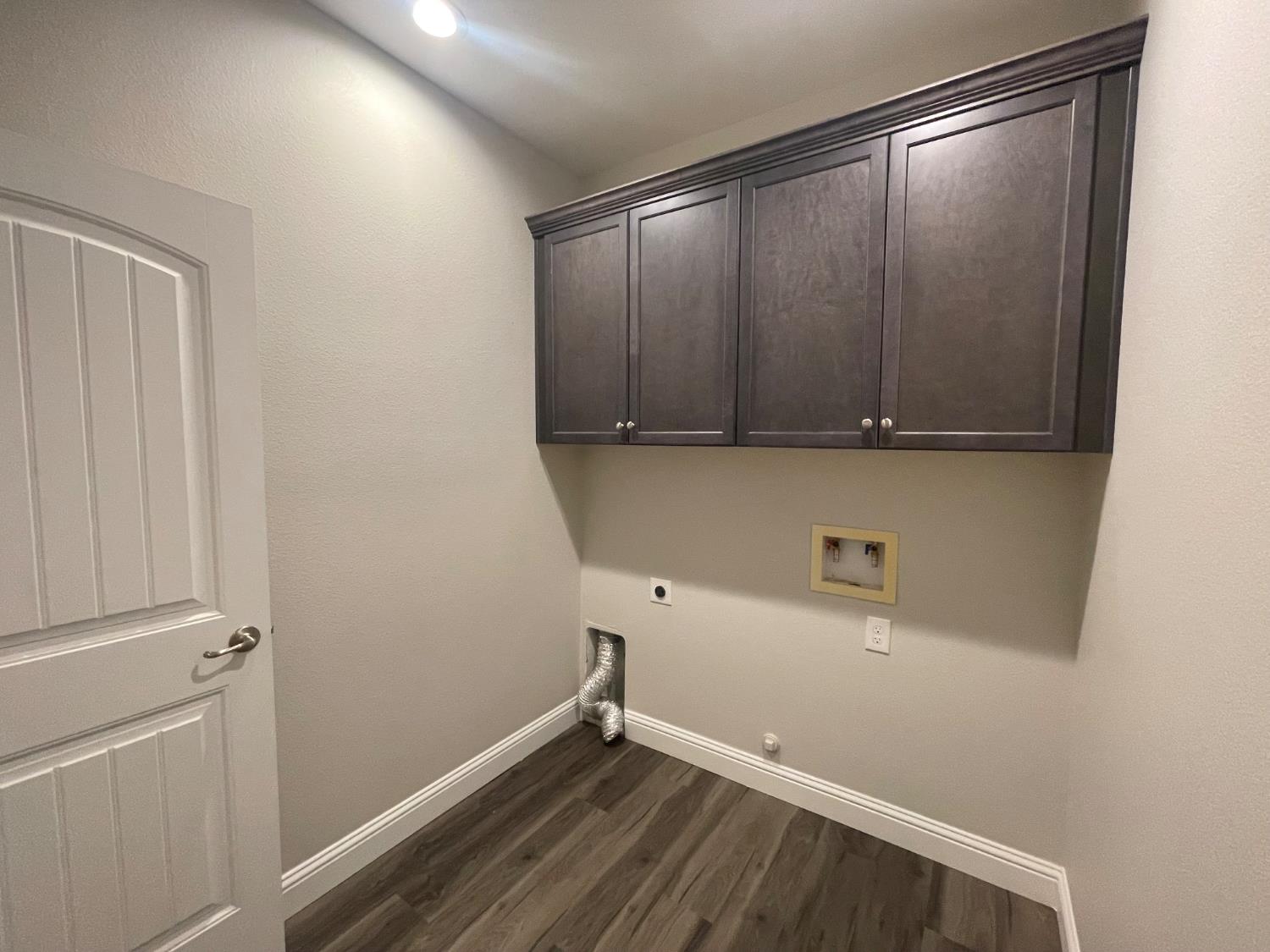 105 South Walnut Avenue Kerman, CA 93630 - Photo 19 of 22 a view of storage and utility room with wooden floor