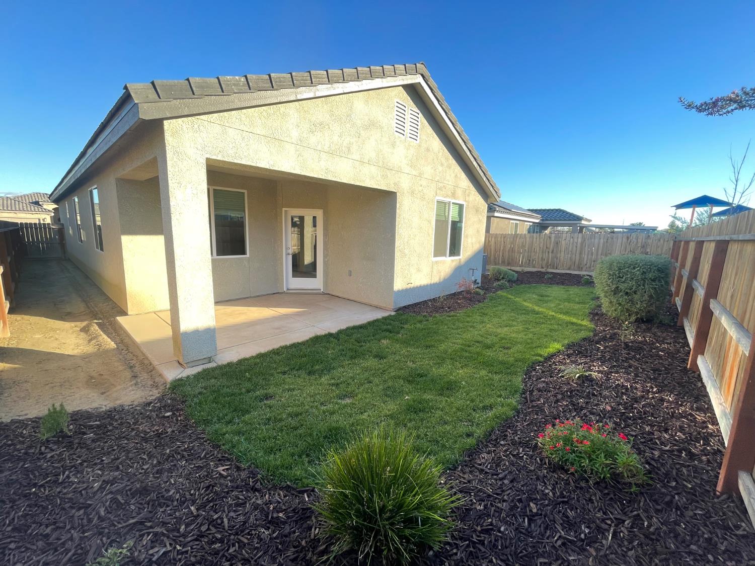 105 South Walnut Avenue Kerman, CA 93630 - Photo 22 of 22 a view of a house with backyard and garden