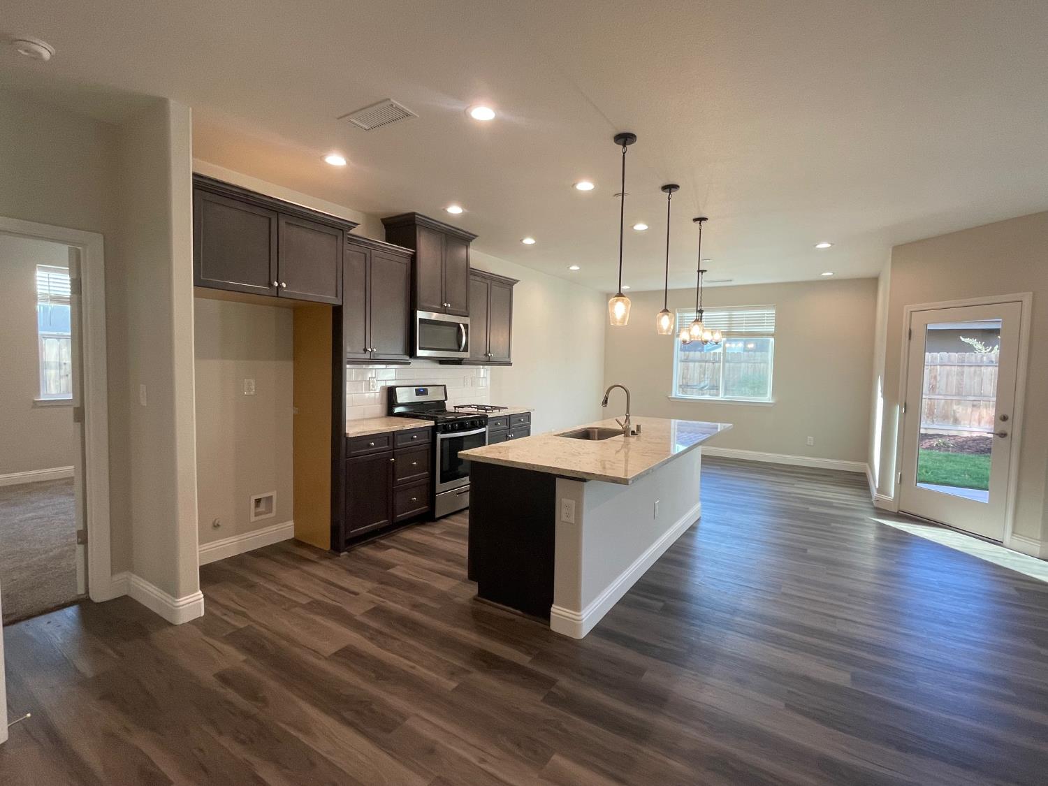 105 South Walnut Avenue Kerman, CA 93630 - Photo 4 of 22 a large kitchen with stainless steel appliances granite countertop a large counter top a sink a refrigerator and a stove