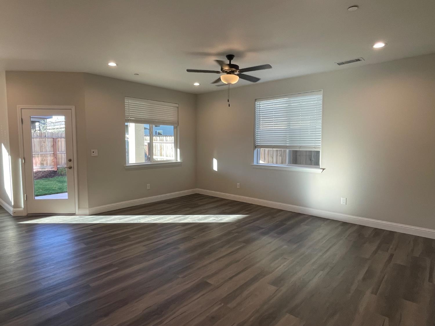 105 South Walnut Avenue Kerman, CA 93630 - Photo 7 of 22 a view of an empty room with wooden floor and a window