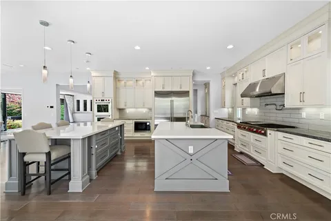 a large kitchen with cabinets wooden floor and stainless steel appliances