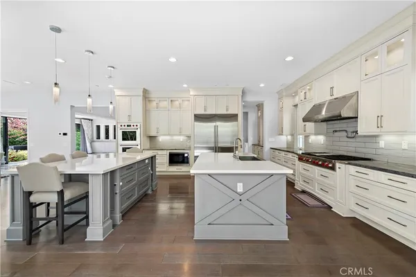 a large kitchen with cabinets wooden floor and stainless steel appliances