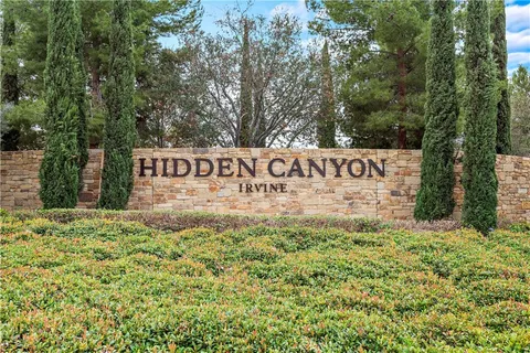 a sign of golf club on a wall under a tree