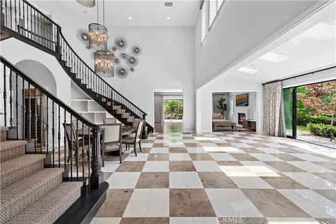 a view of a hallway with wooden floor and a black white checkered floor