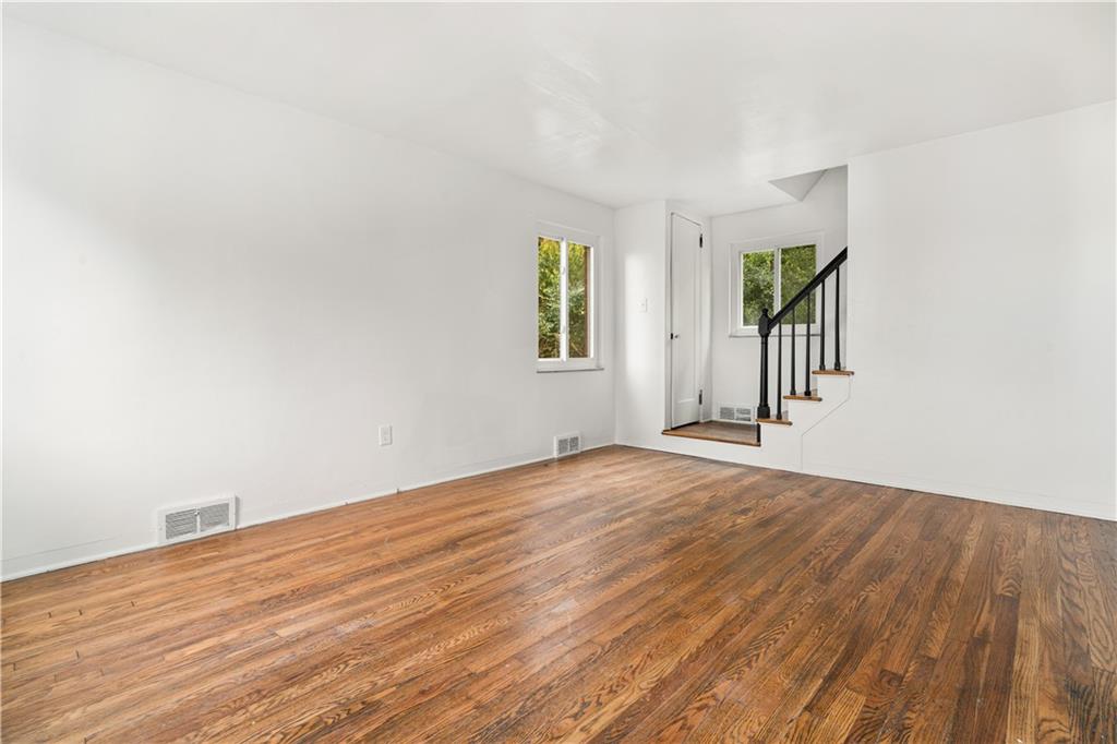 1525 Collins Road Pittsburgh, PA 15221 - Photo 4 of 21 an empty room with wooden floor and windows