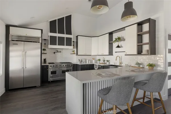 a kitchen with stainless steel appliances granite countertop a stove a refrigerator and a dining table