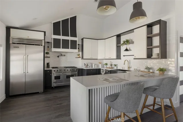 a kitchen with stainless steel appliances granite countertop a stove a refrigerator and a dining table