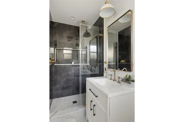 a bathroom with a sink a toilet and shower