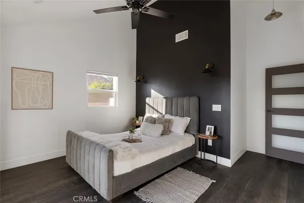 a bedroom with a bed and wooden floor