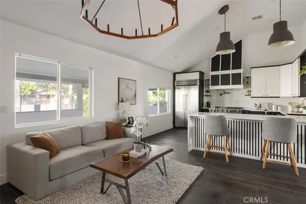 a living room with furniture a fireplace and a chandelier