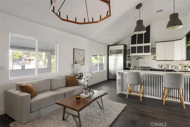 a living room with furniture a fireplace and a chandelier