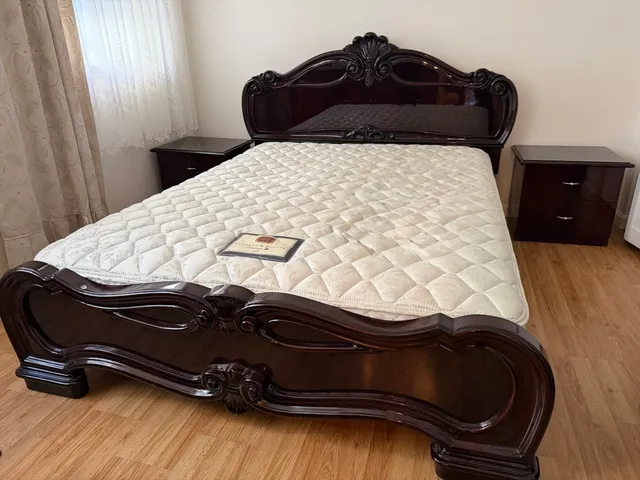 a bed sitting in a bedroom with a black white bedspread and pillows