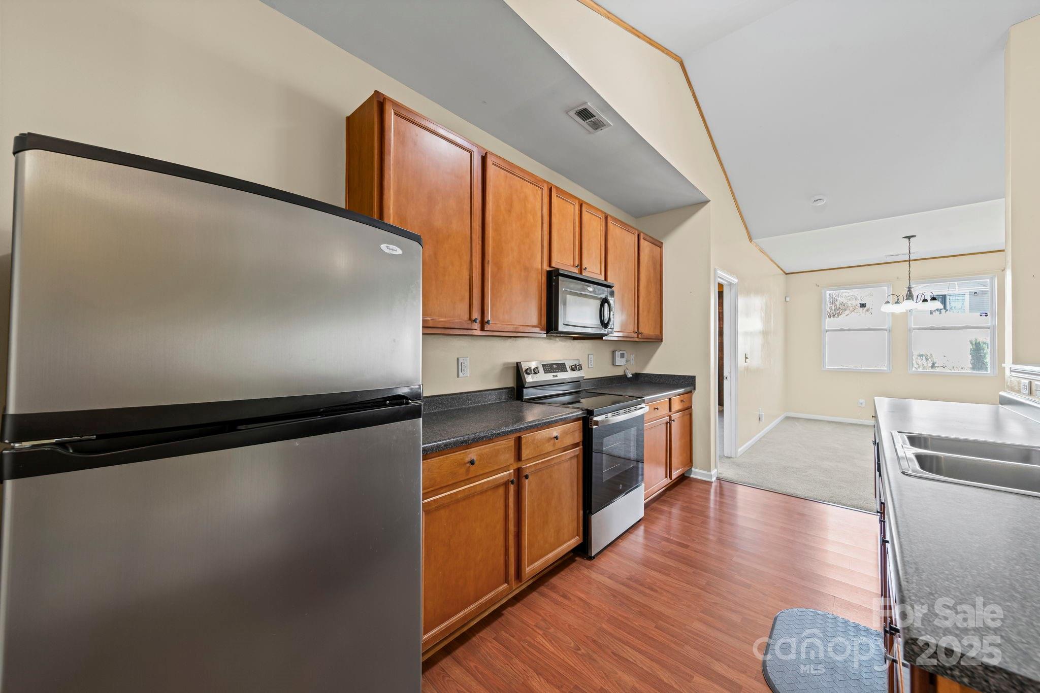 11608 Downy Birch Road Charlotte, NC 28227 - Photo 4 of 38 a large kitchen with stainless steel appliances granite countertop a stove a sink and a refrigerator