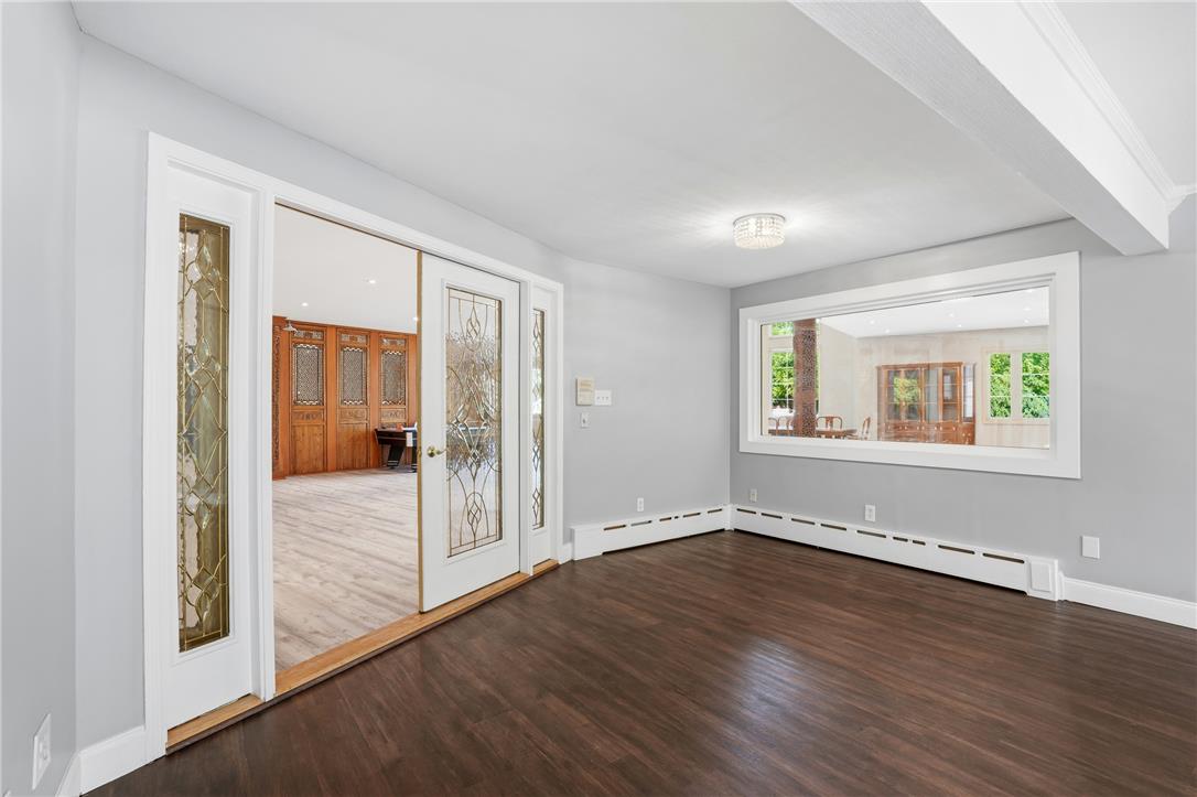 6271 Batman Road Zionsville, PA 18092 - Photo 21 of 100 Rich hardwood flooring stretches across this naturally lit living space, inviting guests through elegant glass-paneled double doors.