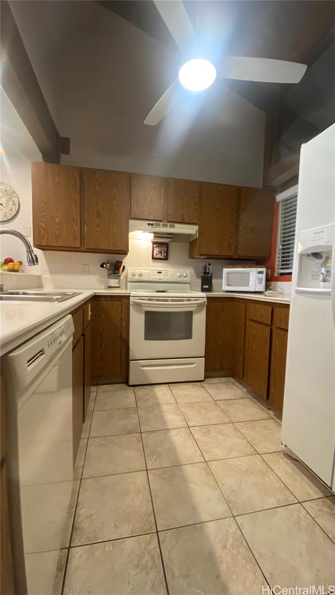 68-3840 Lua Kula Street, Unit E202 Waikoloa, HI 96738 - Photo 6 of 25 a kitchen with a stove top oven and cabinets