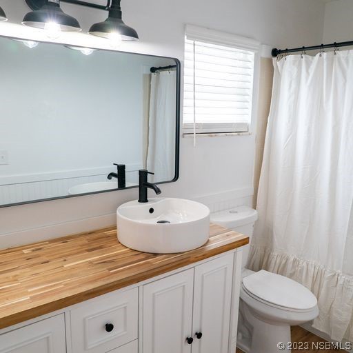3219 Pine Tree Drive Edgewater, FL 32141 - Photo 7 of 13 a bathroom with a sink a toilet and a mirror