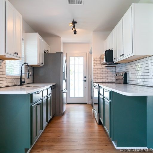 3219 Pine Tree Drive Edgewater, FL 32141 - Photo 8 of 13 a kitchen with stainless steel appliances granite countertop a stove a sink dishwasher and a refrigerator with wooden cabinets