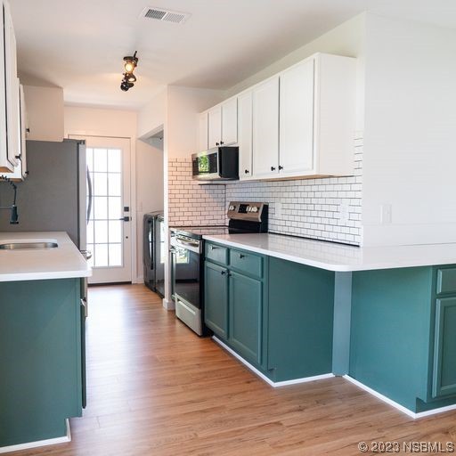 3219 Pine Tree Drive Edgewater, FL 32141 - Photo 9 of 13 a kitchen with stainless steel appliances granite countertop a wooden cabinets a stove a sink and a refrigerator