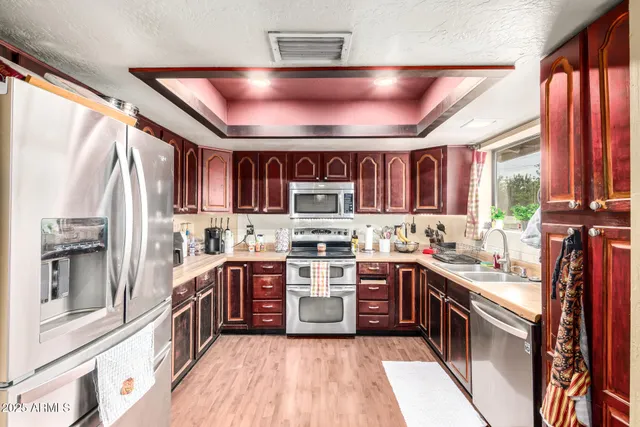 a kitchen with stainless steel appliances granite countertop lots of counter top space a sink and a window