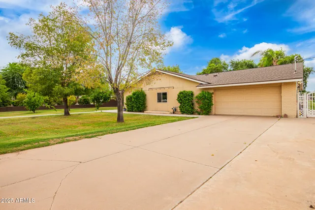 a front view of a house with a yard and trees
