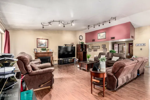 a living room with furniture a flat screen tv and a fireplace