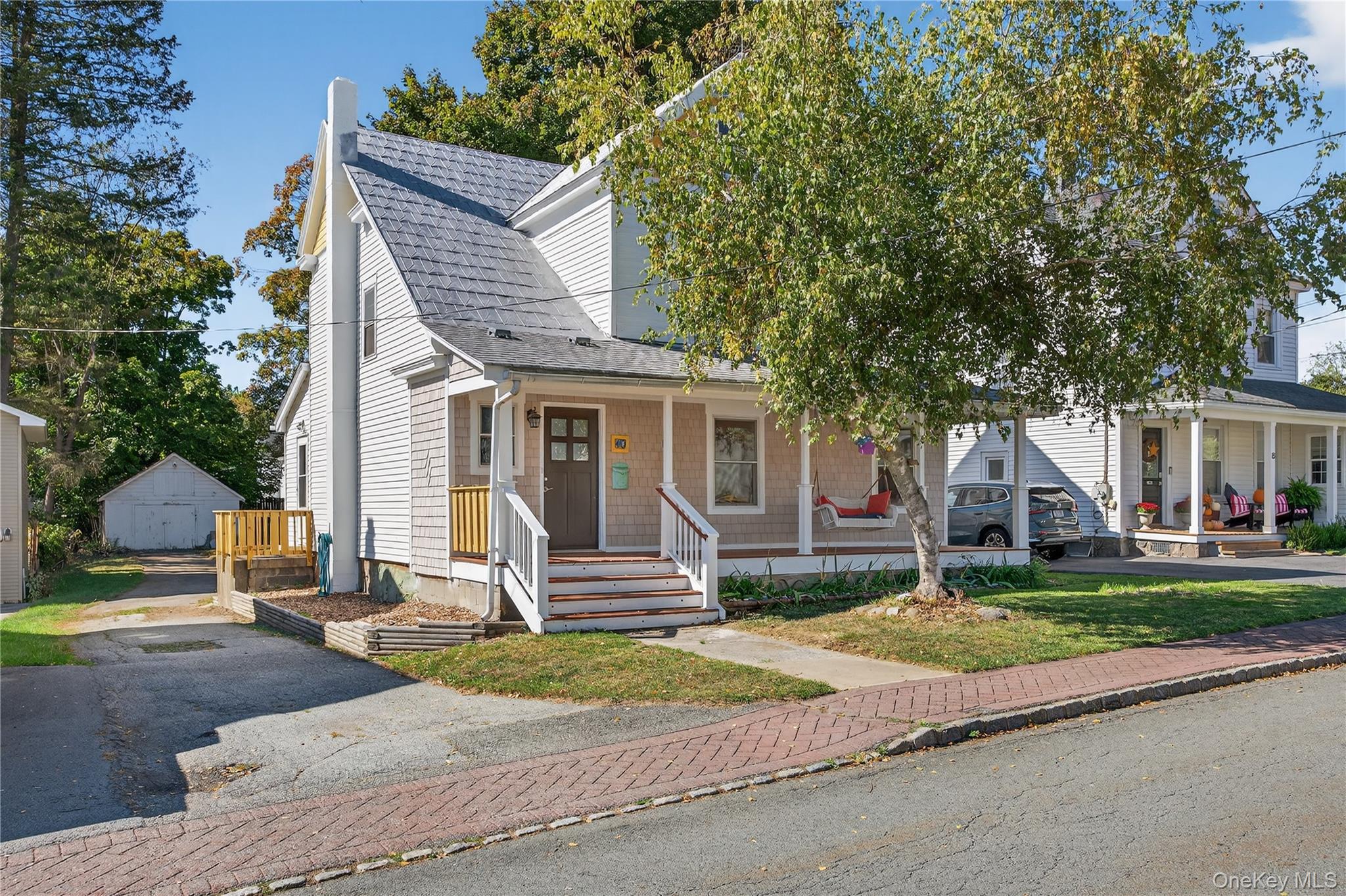 a front view of a house with a garden and trees