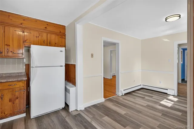 a view of a kitchen with wooden floor and a refrigerator