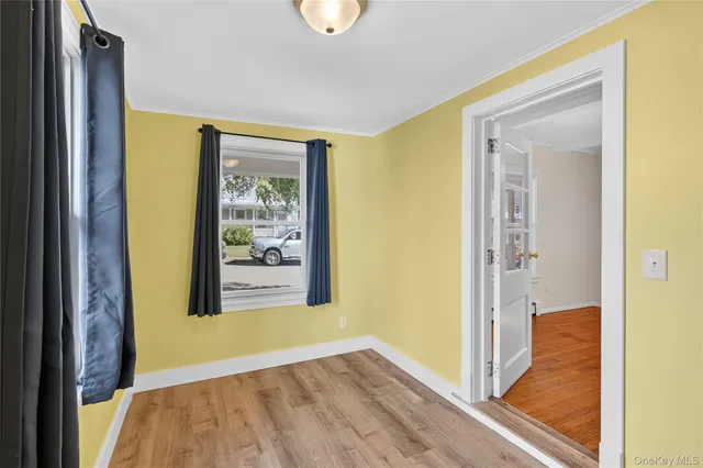 a view of a hallway with wooden floor and a dining room