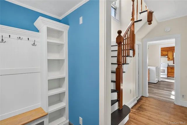 a view of a hallway with wooden floor and entryway