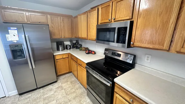 a kitchen with stainless steel appliances a refrigerator a sink a stove a microwave and cabinets