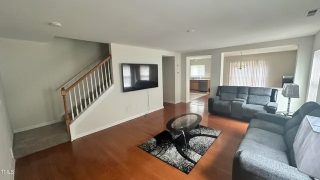 a living room with furniture and a wooden floor
