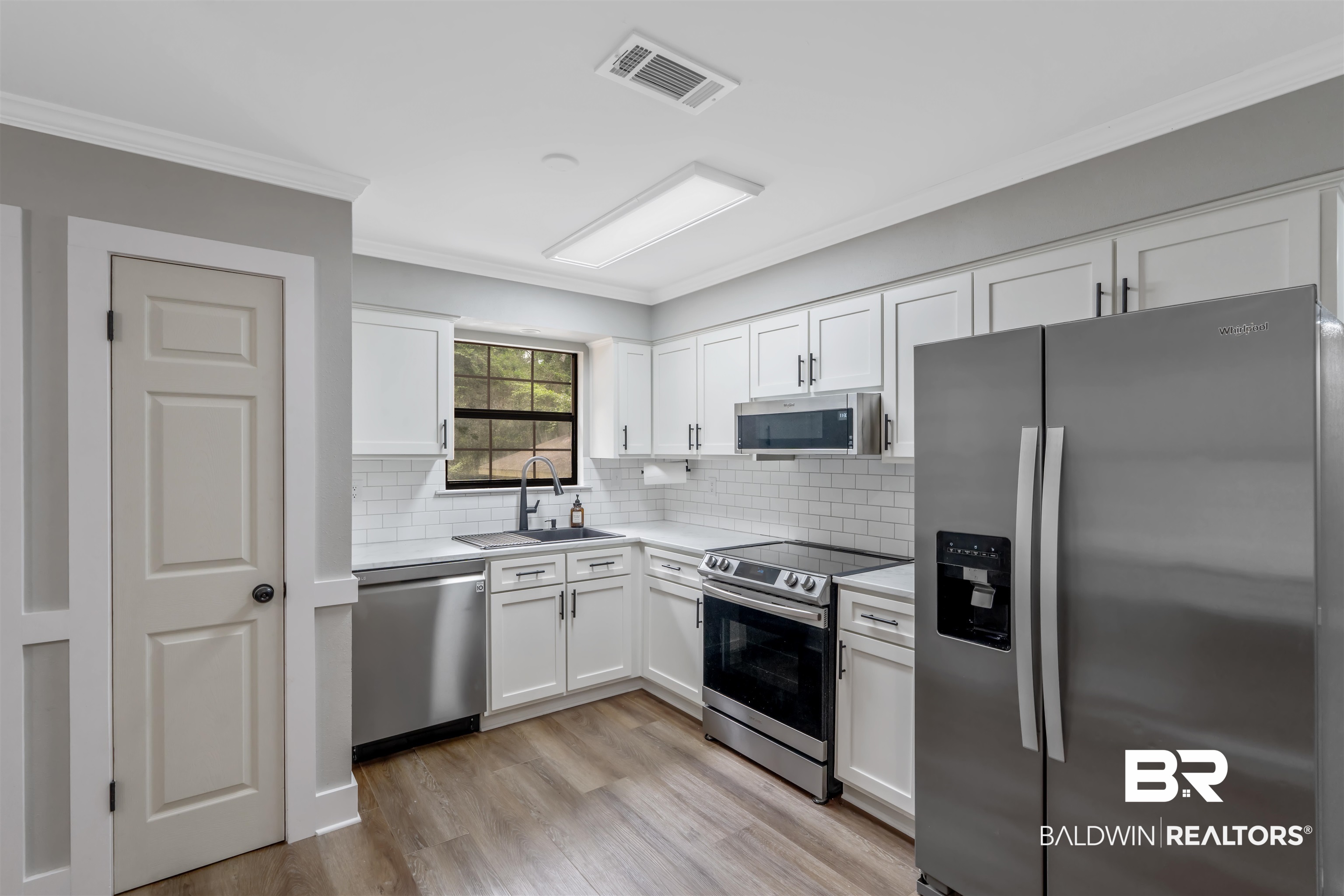 147 Richmond Road Daphne, AL 36526 - Photo 9 of 27 Kitchen featuring stainless steel appliances, light countertops, white cabinetry, crown molding, and decorative backsplash