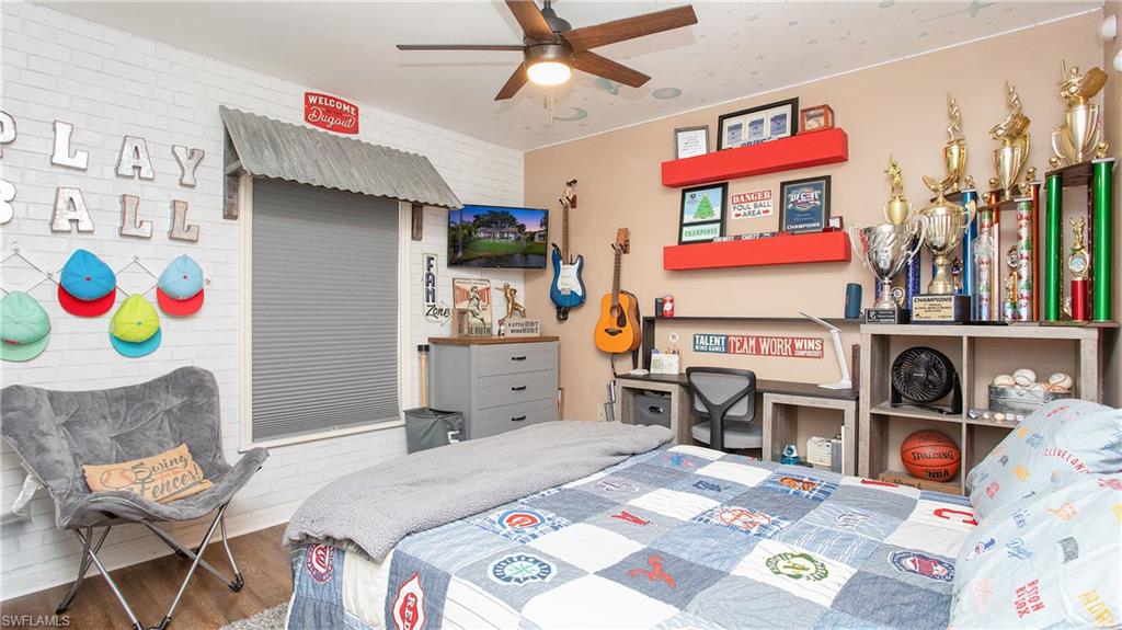 17269 Lee Road Fort Myers, FL 33967 - Photo 13 of 26 Bedroom with wood-type flooring, brick wall, and ceiling fan